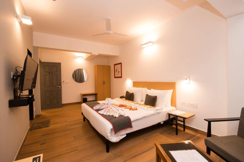 a hotel room with a bed and a television at Hotel Vemara in Panaji