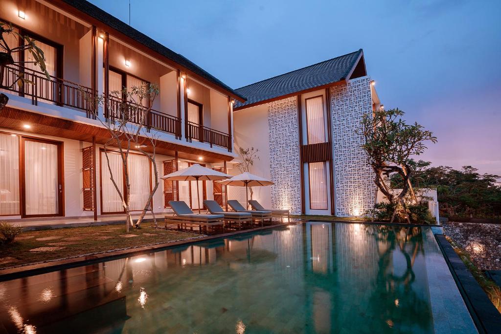 a house with a swimming pool in front of a building at One Degree Sunset Hill Leisure in Uluwatu