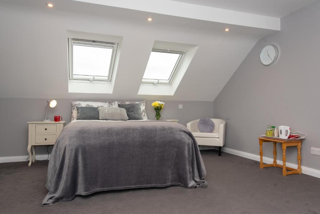 a bedroom with a large bed and two windows at Worthing bright and cosy double room in Worthing
