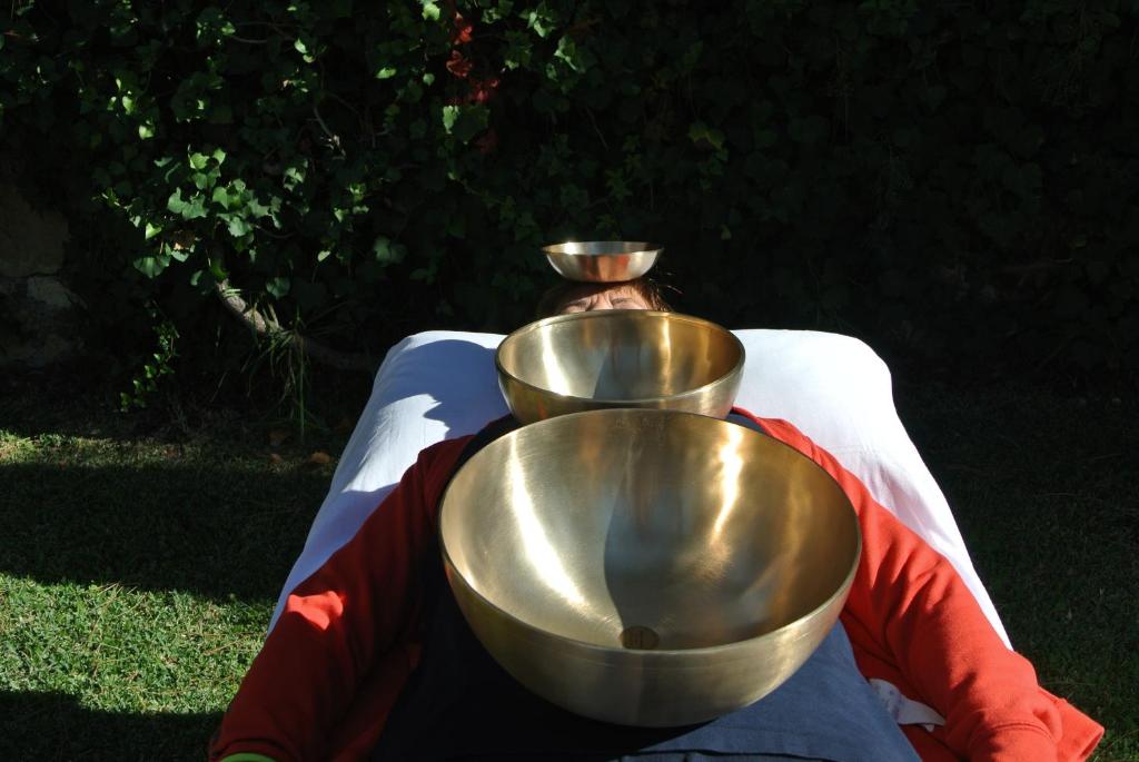 a man laying on a blanket with two gold bowls on his back at BUBA BnB SUPERIOR in Anzio