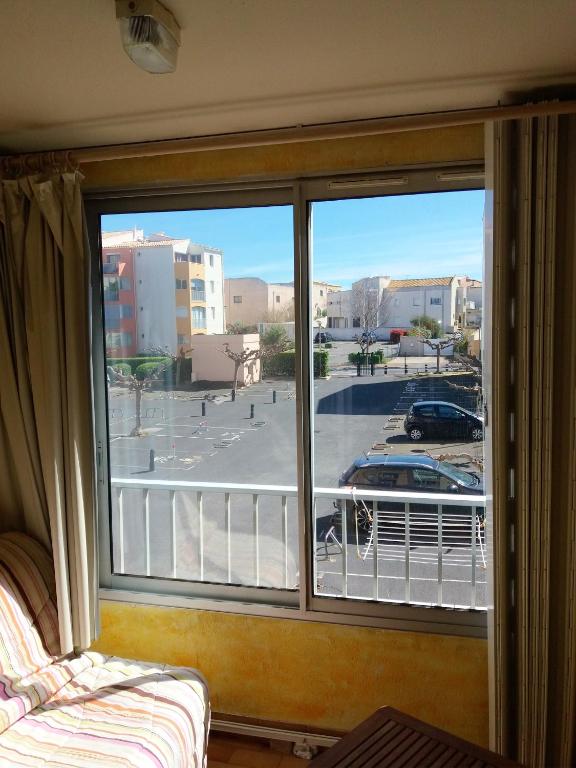 une fenêtre avec vue sur un parking dans l'établissement Charmant studio à Agde de 21 m² avec terrasse vue ville, au Cap d'Agde