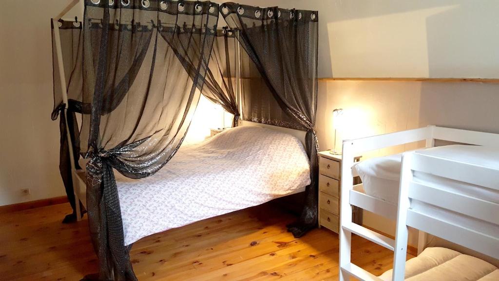 a bedroom with a canopy bed and a wooden floor at Demeure de 6 chambres avec piscine interieure jacuzzi et jardin clos a Vernou sur Brenne in Vernou-sur-Brenne