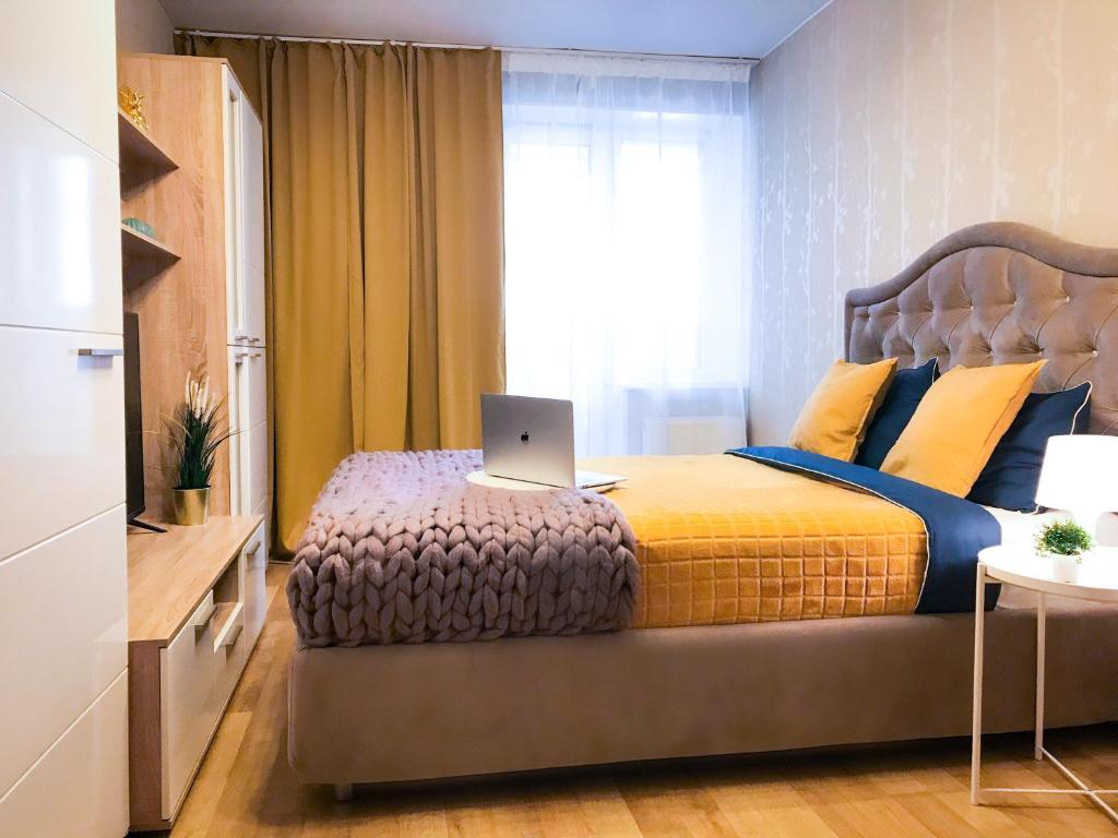 a bedroom with a bed with a laptop on it at Merino Home Family in Saint Petersburg