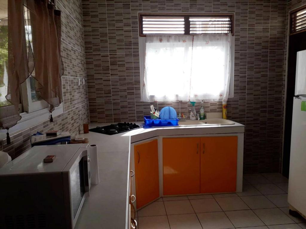 a kitchen with a sink and a stove and a window at Maison de 3 chambres avec vue sur la mer terrasse et wifi a Vieux Habitants in Vieux-Habitants