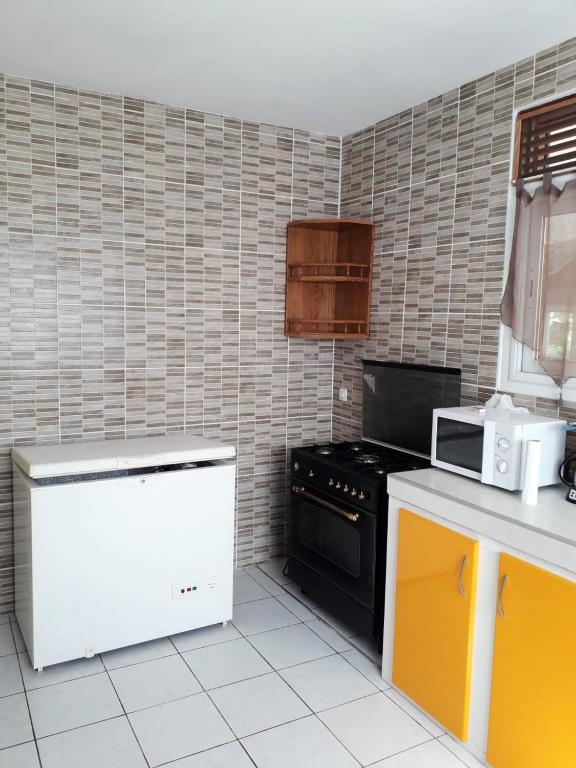 a kitchen with a black stove and a microwave at Maison de 3 chambres avec vue sur la mer terrasse et wifi a Vieux Habitants in Vieux-Habitants