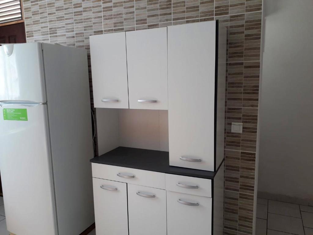 a kitchen with white cabinets and a refrigerator at Maison de 3 chambres avec vue sur la mer terrasse et wifi a Vieux Habitants in Vieux-Habitants