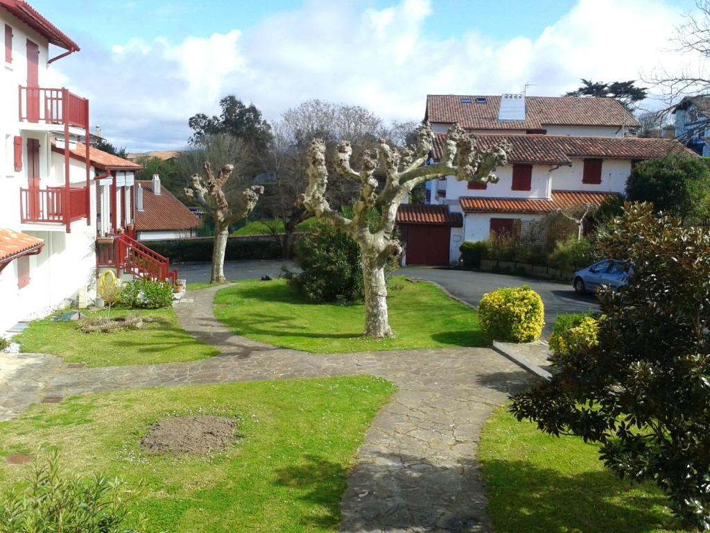 un jardín en una casa con árboles y un camino de entrada en Studio a Guethary a 150 m de la plage avec jardin clos, en Guéthary