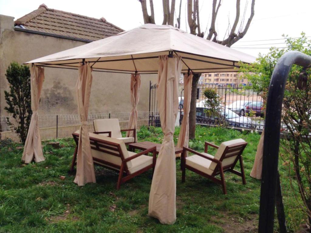 a gazebo with chairs and a table in the grass at Appartement confortable à Roanne avec jardin et parking in Roanne