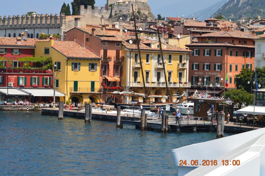 un barco en una masa de agua con edificios en The Swan B&B, en Manerba del Garda