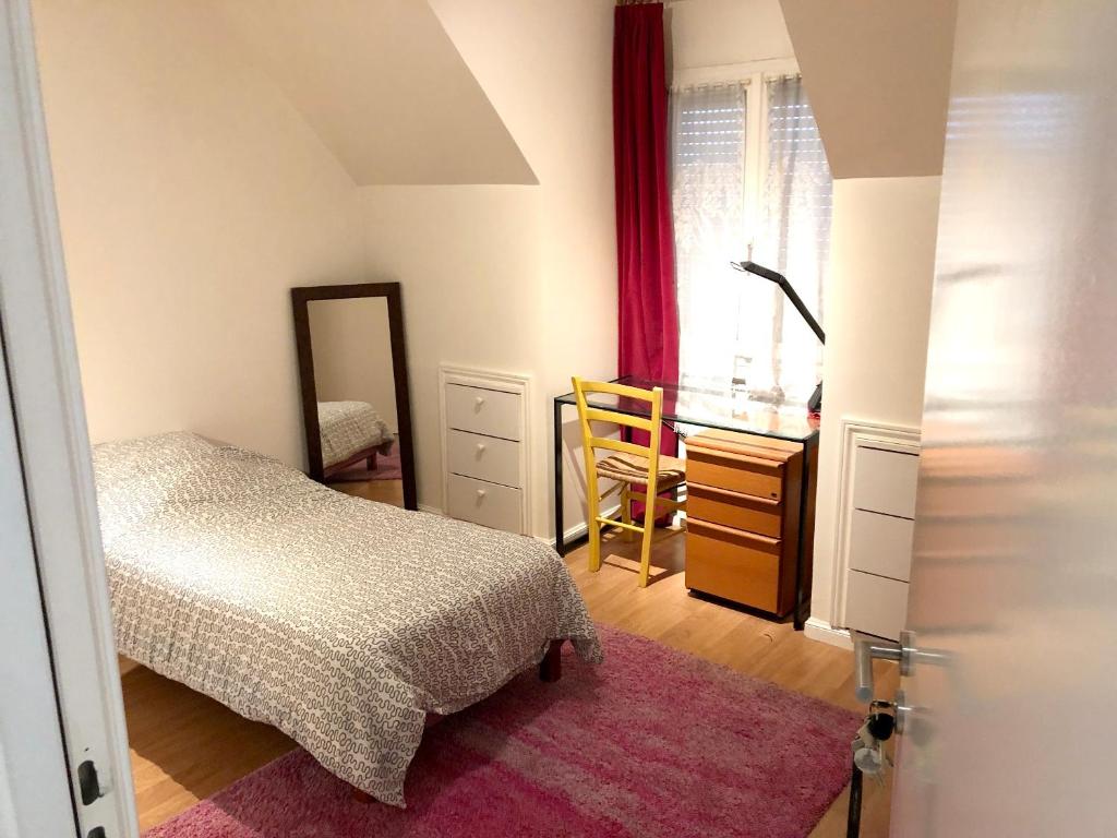 um quarto com uma cama, uma cómoda e um espelho em Appartement de 3 chambres avec jardin clos et wifi a Sannois em Sannois