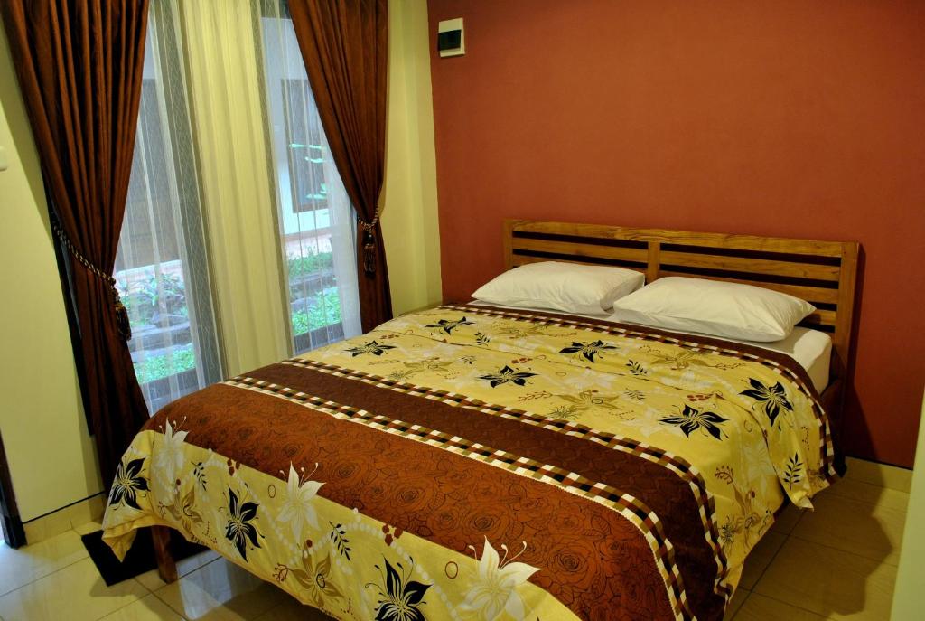 Postel nebo postele na pokoji v ubytování Aloha Hotel Yogyakarta