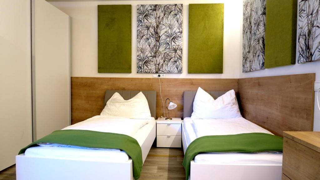 two beds in a room with green and white at Privatzimmer Vermietung Helmut Bürgmann in Kirchberg bei Mattighofen