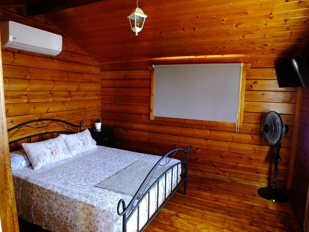 um quarto com uma cama num chalé de madeira em La Cabaña em Guía de Isora