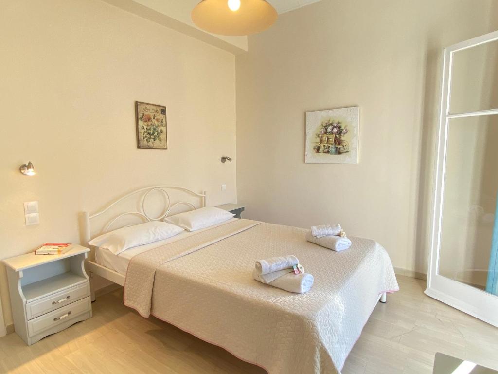 a bedroom with two beds and a window at Nikos Cassiopeia in Kassiopi