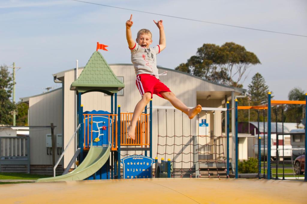 młody chłopiec skaczący z placu zabaw w obiekcie Discovery Parks - Gerroa w mieście Gerroa