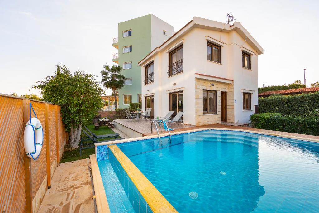 a villa with a swimming pool in front of a house at Buena Vista Villa in Protaras