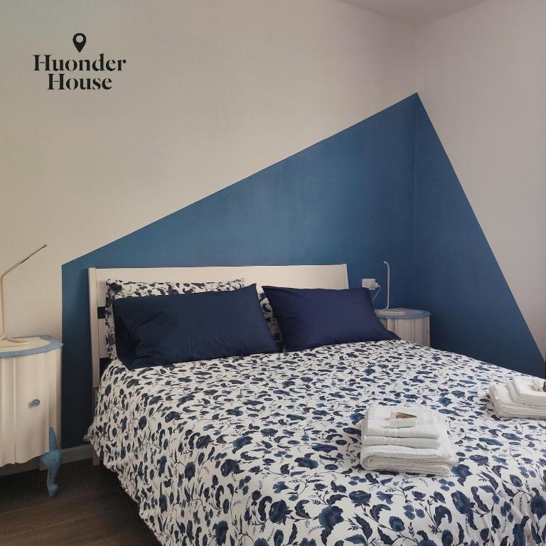 a bedroom with a blue and white bed with towels on it at Huonder House in Lecco