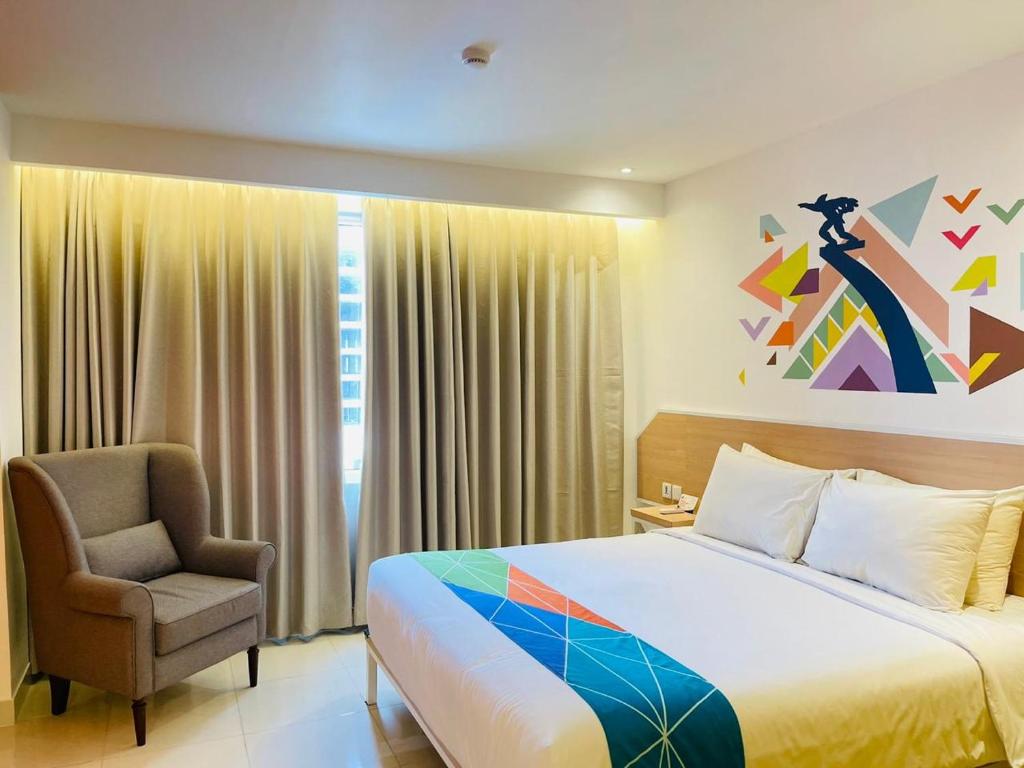 um quarto de hotel com uma cama e uma cadeira em Dafam Express Jaksa Jakarta em Jakarta