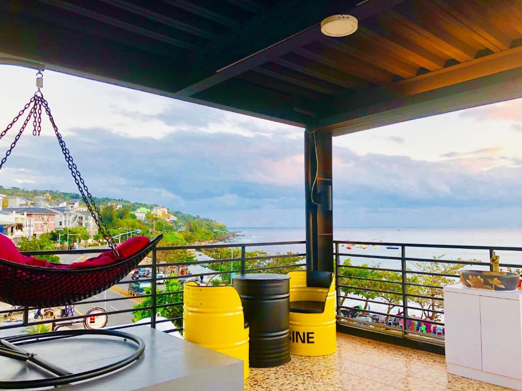 a hammock on a balcony with a view of the ocean at The First Nanwan Hostel in Nanwan