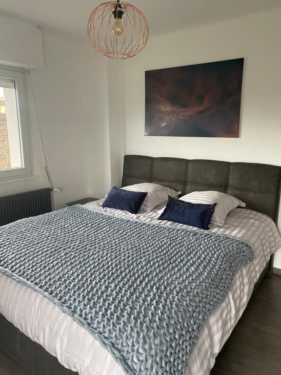 a bedroom with a large bed with blue pillows at Gîte Célia in Sélestat