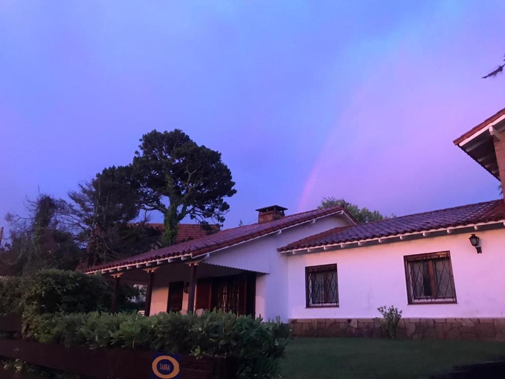 een regenboog in de lucht boven een huis bij Cruz del Sur in Pinamar