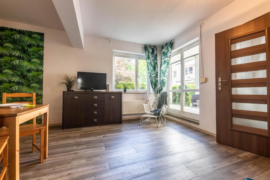 salon z drewnianą podłogą i oknem w obiekcie Victus Apartamenty, Apartament Bella w mieście Sopot