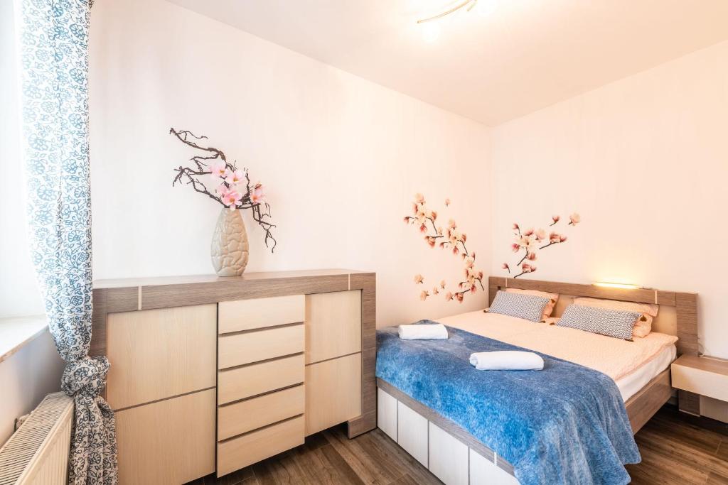 niewielka sypialnia z łóżkiem i komodą w obiekcie Victus Apartamenty, Apartament Bella w mieście Sopot