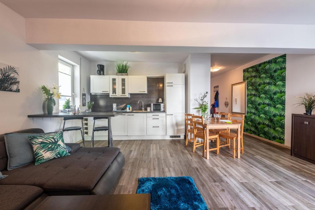 salon i kuchnia z kanapą i stołem w obiekcie Victus Apartamenty, Apartament Bella w mieście Sopot