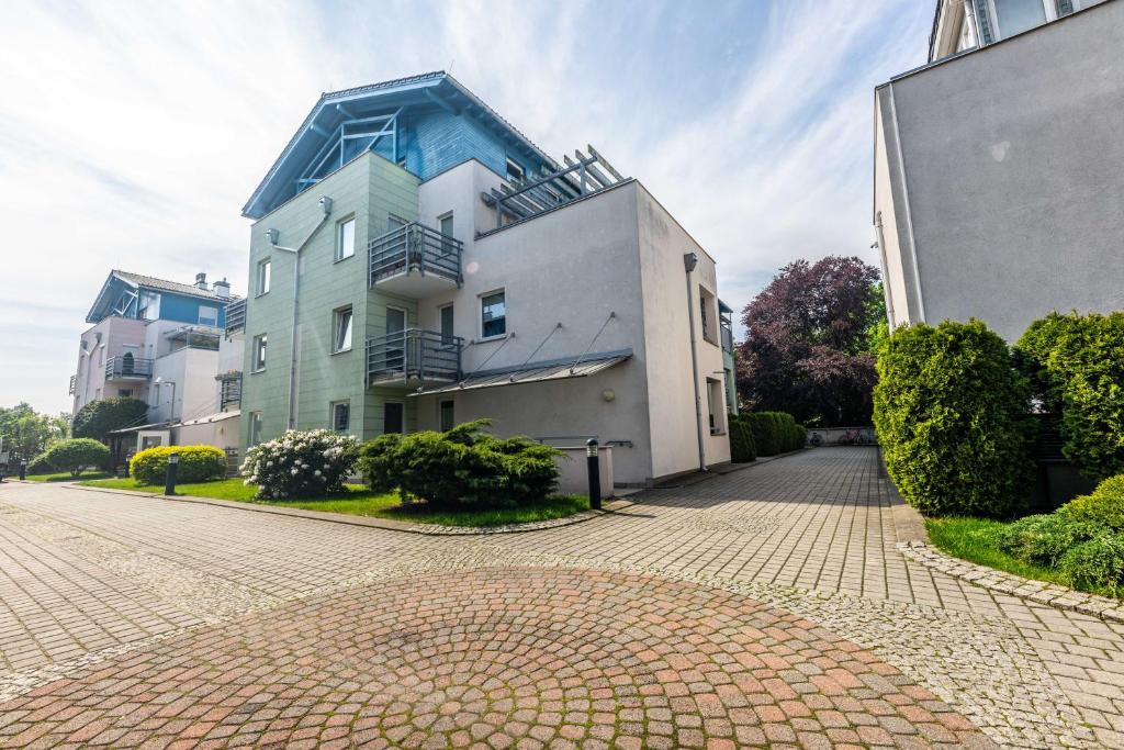 duży budynek przy ceglanej drodze obok budynku w obiekcie Victus Apartamenty, Apartament Bella w mieście Sopot