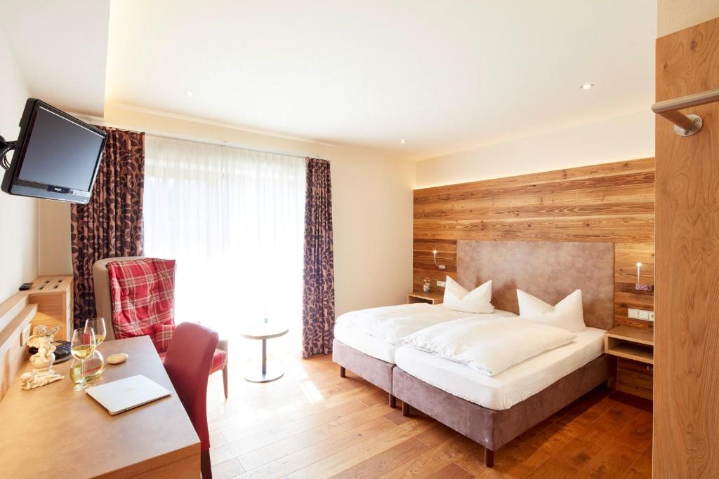 a hotel room with a bed and a desk and a television at Landgasthof Fiedler in Dietersheim