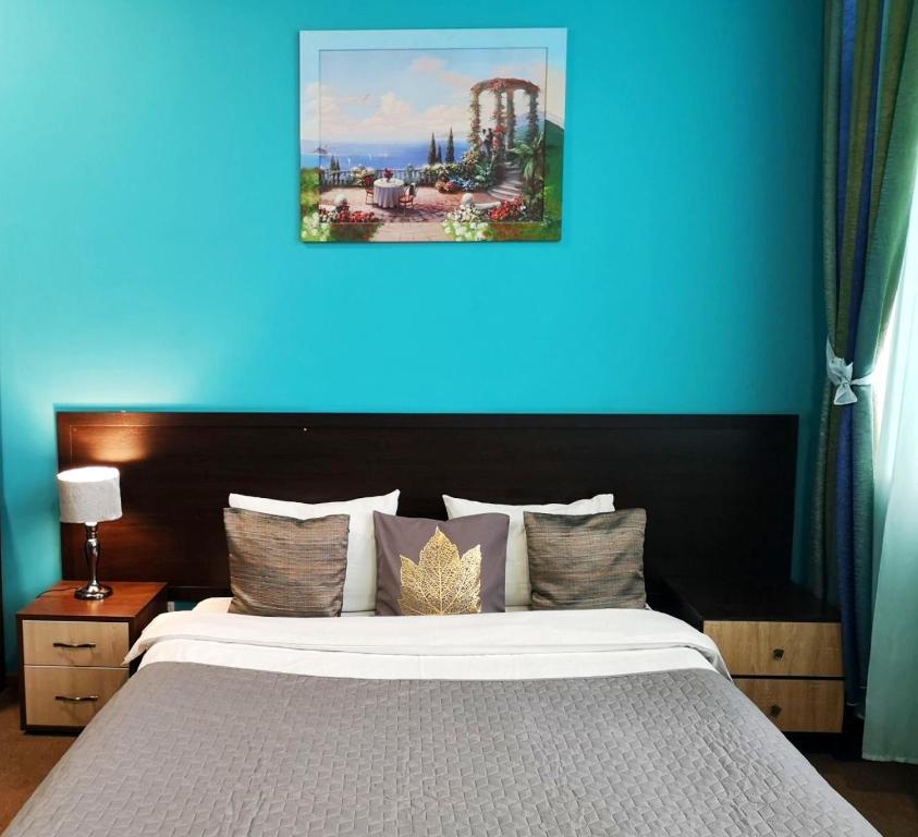 um quarto com uma cama com uma parede azul em Orange Hotel em Lviv