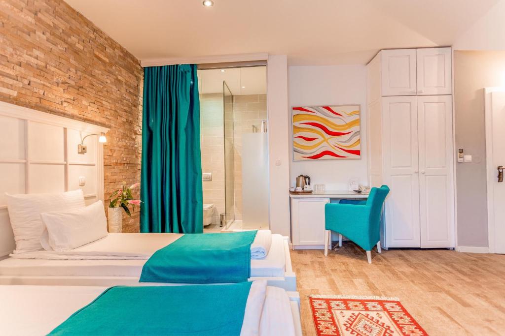a bedroom with a bed and a blue chair at Hotel-Restaurant Kriva Ćuprija in Mostar