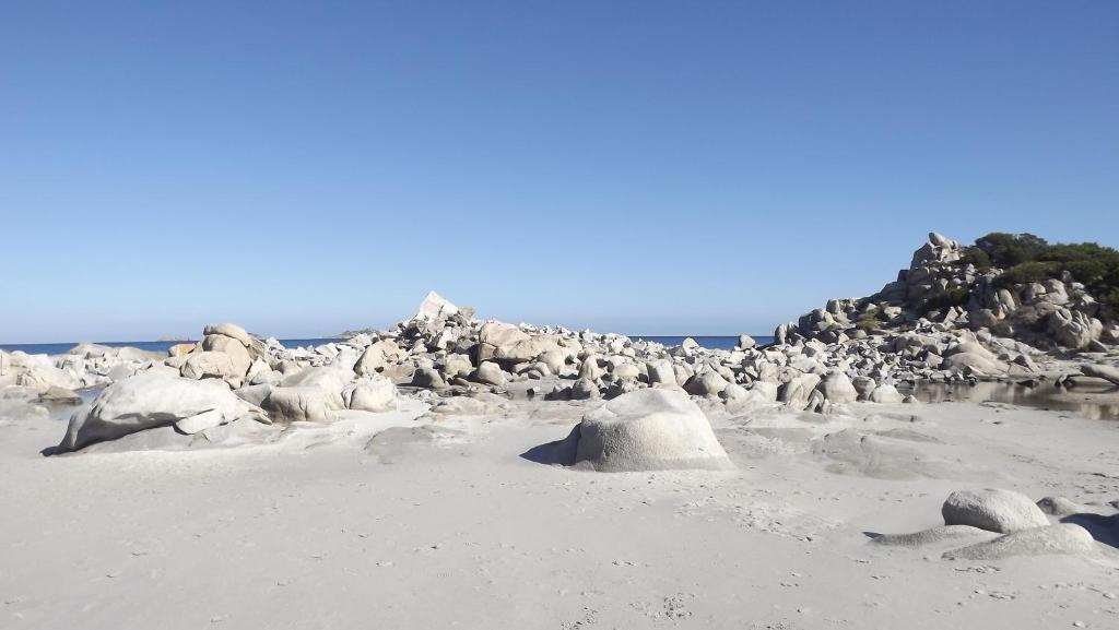 a group of rocks on a sandy beach at VILLA CLAUDIO e LUNETTA in Villasimius