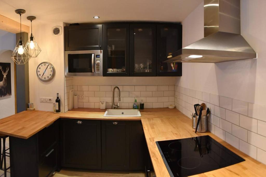 - une cuisine avec des placards noirs et un évier dans l'établissement Sleeps6-PetFriendly&Garden-Hiking-Paragliding, à Morzine