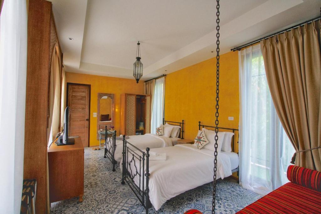 uma cama de baloiço num quarto com duas camas em The Ryad Rayong em Mae Pim