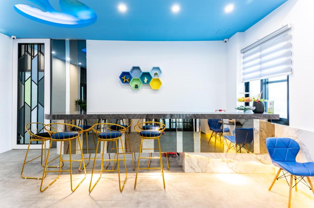 馬公市的住宿－海派甜心民宿，厨房配有黄色和蓝色的酒吧凳