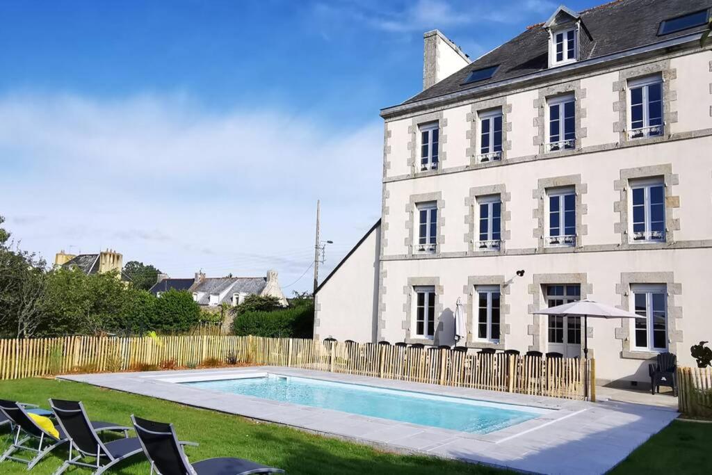 una piscina frente a una casa en Maison de famille Penmarch, en Penmarch