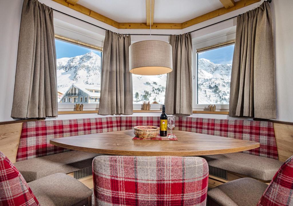 - une table dans une chambre avec vue sur les montagnes enneigées dans l'établissement Apartments & Garni Alpenrose, à Obertauern