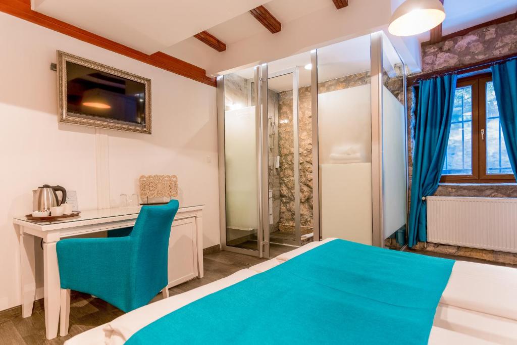 a hotel room with a bed and a television at Hotel-Restaurant Kriva Ćuprija in Mostar
