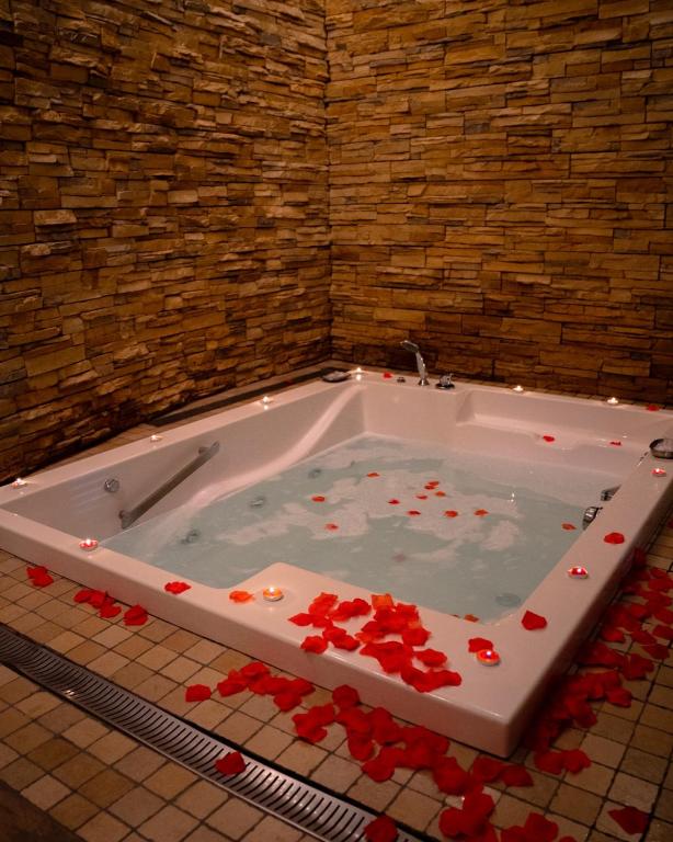 una vasca da bagno piena di rose rosse in bagno di Hotel Ginepro a Qualiano