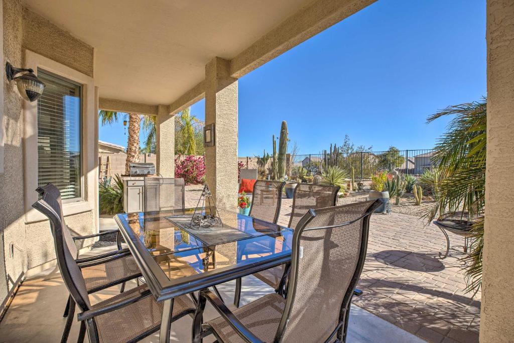 a glass table and chairs on a patio at Sunny San Tan Valley Home with Grill on Golf Course! in Magma