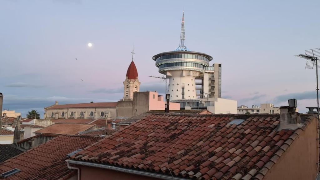 vista su una città con tetti e una torre di appartement atypique en duplex a Palavas-les-Flots