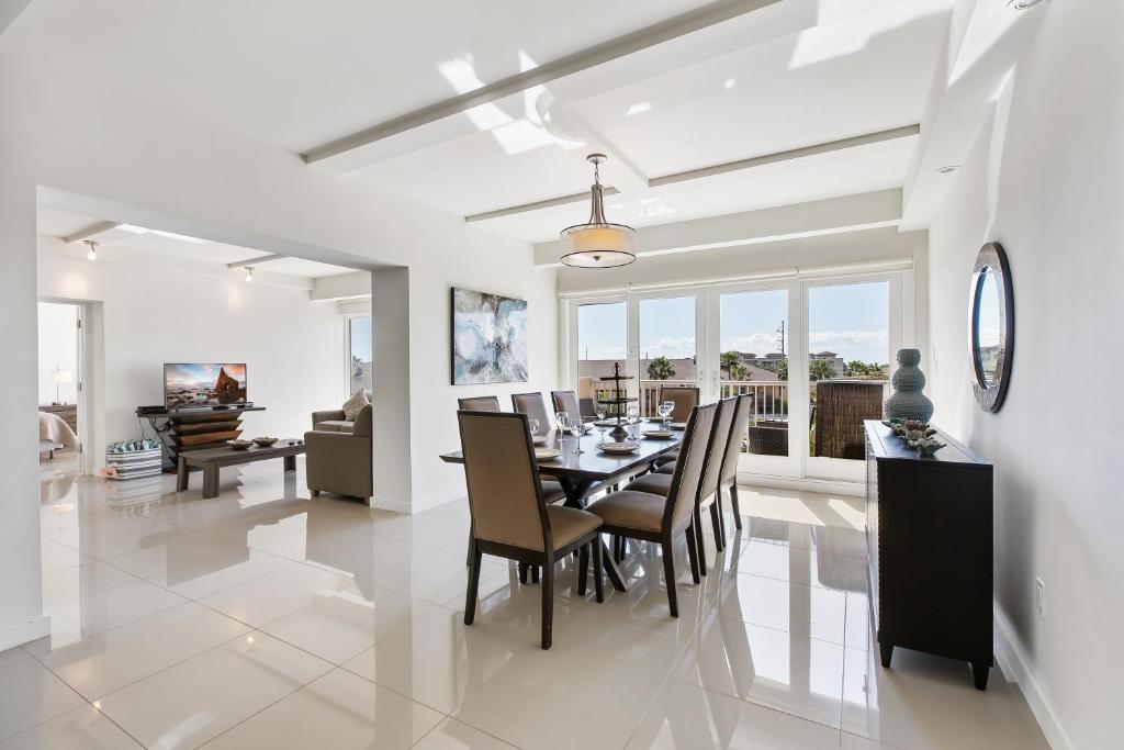 comedor y sala de estar con mesa y sillas en Perfect condo, room for everyone! Beachfront resort, en South Padre Island