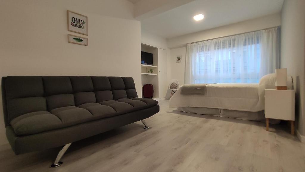 a living room with a couch and a bed at Departamento centro mdp calle belgrano in Mar del Plata
