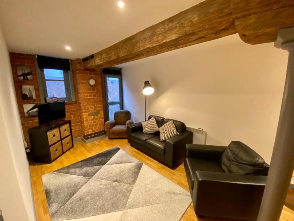 een woonkamer met een bank en een stoel bij Stewart Docks Apartment in Gloucester