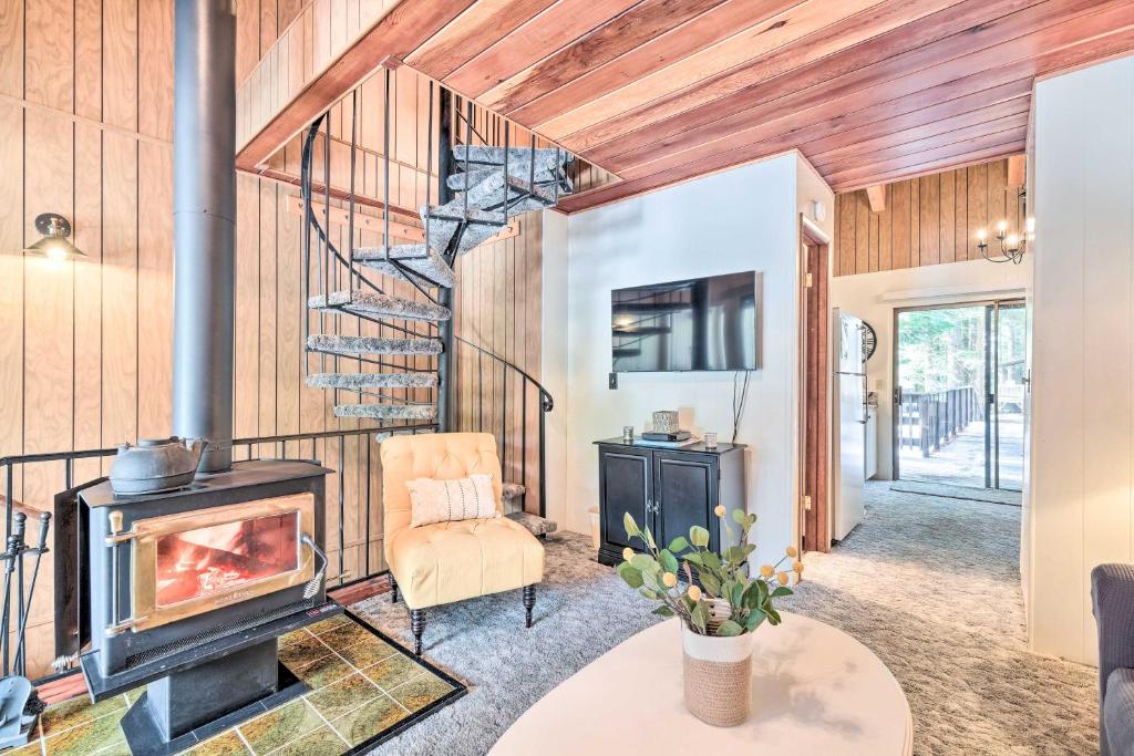 a living room with a woodburning stove and a chair at Pinecrest Retreat with Fireplace! in Pinecrest