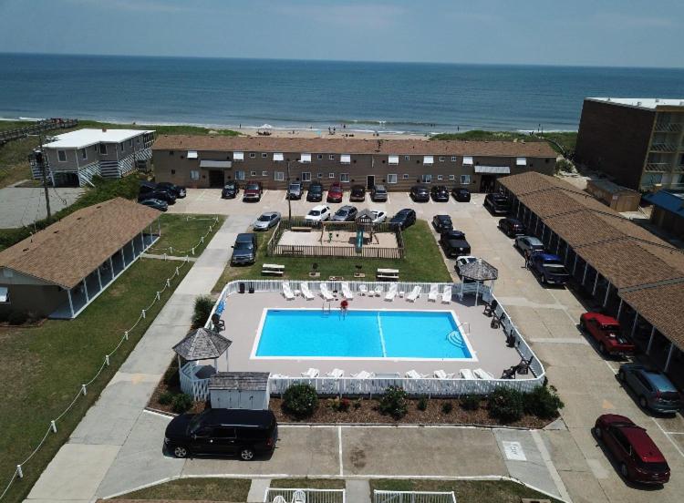 uma vista aérea de um parque de estacionamento com piscina e oceano em Outer Banks Motor Lodge em Kill Devil Hills