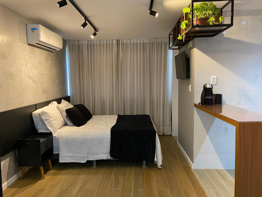 a small room with a bed and a window at Apartamento Studio Maceió in Maceió