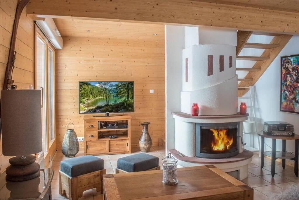 a living room with a fireplace in a house at Chalet Charligustine - Gérardmer - 8p (4 étoiles) in Gérardmer