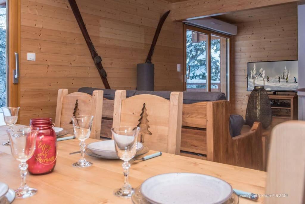 a wooden table with wine glasses on top of it at Chalet Charligustine - Gérardmer - 8p (4 étoiles) in Gérardmer